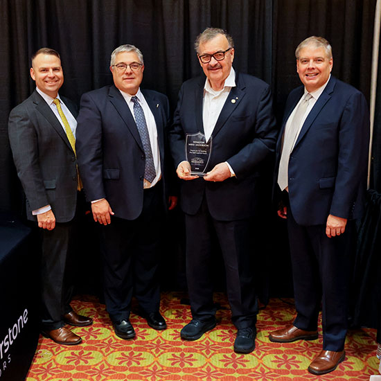 Four men holding an award